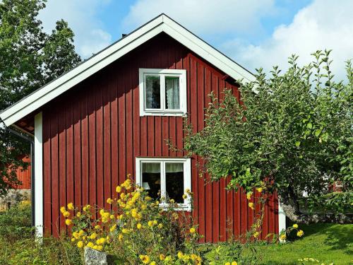 a red house with a white window and some flowers at 5 person holiday home in V DD in Veda