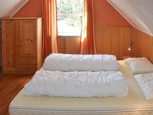 a bedroom with two beds with white sheets and a window at Holiday home leikanger in Leikanger