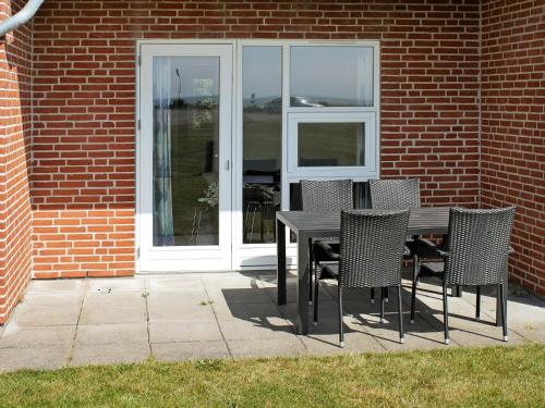 a table and chairs in front of a building at 6 person holiday home in H jer in Emmerlev