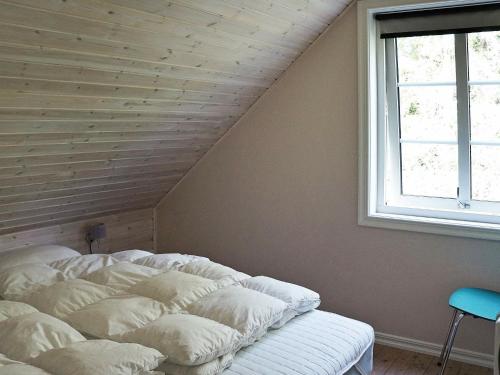 Bett mit Kissen in einem Zimmer mit Fenster in der Unterkunft Three-Bedroom Holiday home in Hallabro in Hallabro