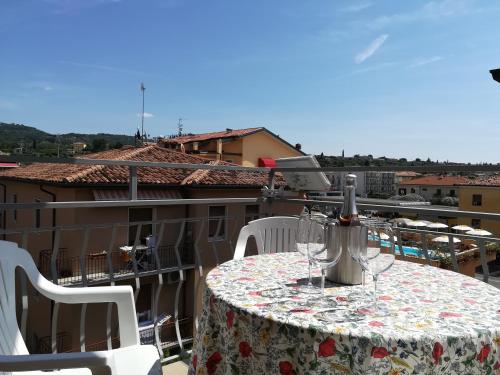 - une table avec des verres à vin sur le balcon dans l'établissement SWEET IRENE Deluxe, à Bardolino