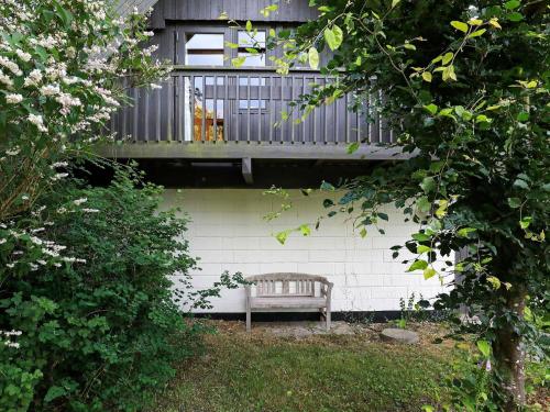 un banco de madera en un patio con balcón en 6 person holiday home in Struer en Struer