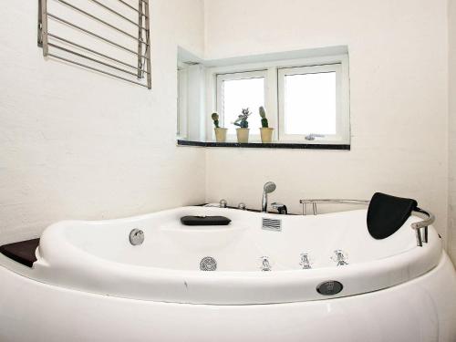 y baño con bañera blanca y espejo. en 8 person holiday home in Hals en Hals
