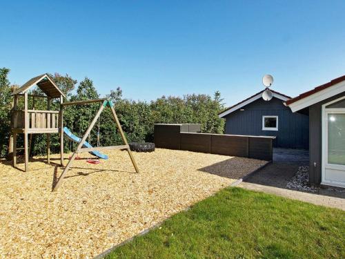 un parque infantil con columpio en un patio en 6 person holiday home in Hemmet, en Hemmet