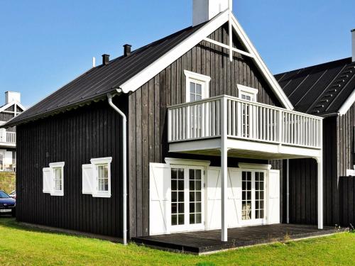 a black and white house with a balcony at 8 person holiday home in Gjern-By Traum in Gjern
