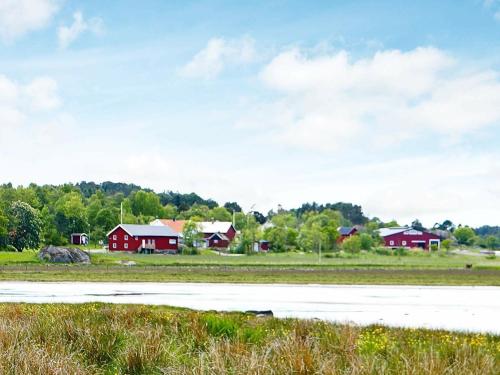 un grupo de casas rojas en un campo junto a una pista en 5 person holiday home in VAREKIL en Varekil