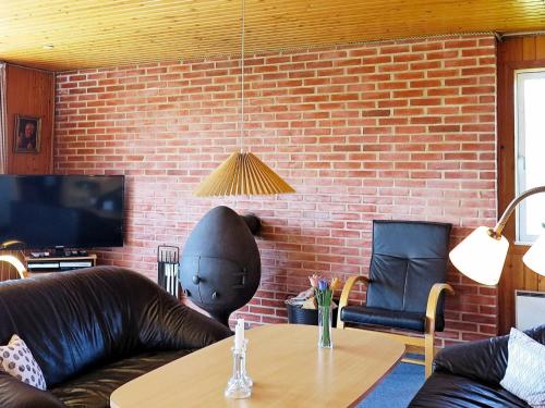 a living room with a couch and a brick wall at 8 person holiday home in Harbo re in Vrist