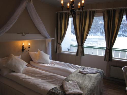 En eller flere senge i et værelse på Hjelle Hotel