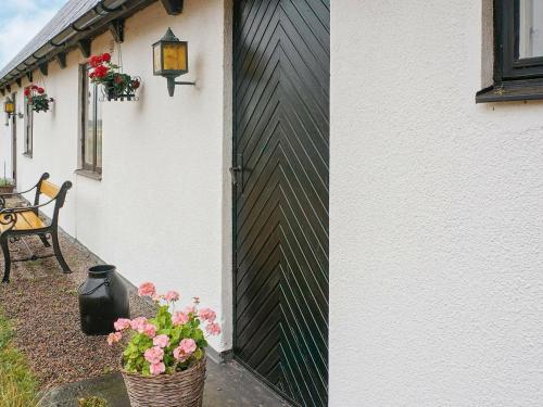 ラホルムにある6 person holiday home in Laholmの白黒の柵と花の家