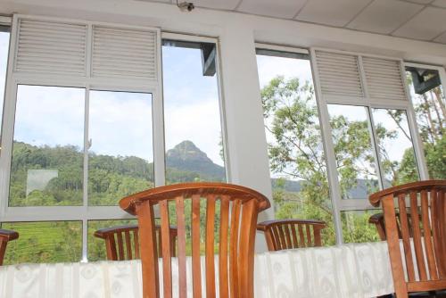 a room with four chairs and windows with a view at Punsisi Resort - Adam's Peak in Adams Peak