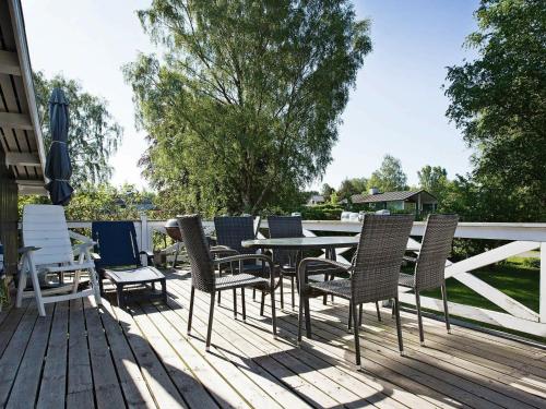a wooden deck with chairs and a table and a fence at 6 person holiday home in Str by in Strøby