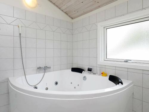 Spodsbjergにある8 person holiday home in Rudk bingの窓付きのバスルーム(白いバスタブ付)