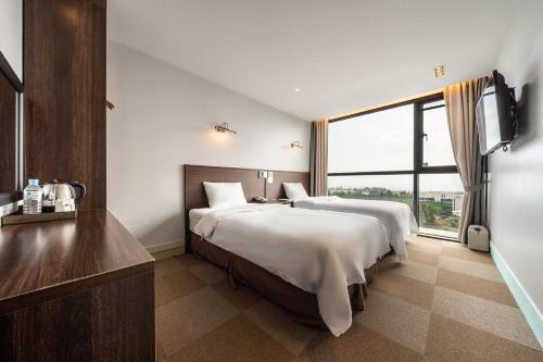 Postel nebo postele na pokoji v ubytování Sunrise Hotel Jungmun Branch