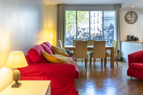 sala de estar con sofá rojo y mesa en Paris City - Spacious 3 rooms flat for families - 3 minutes from metro station, en París