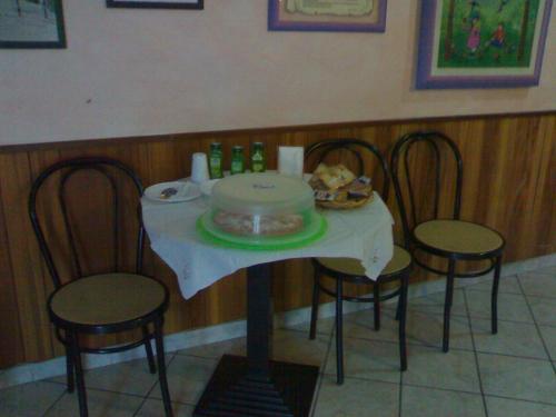 een tafel met een taart erop, die op een tafel met stoelen staat bij Bed&Breakfast Castagna in Carlopoli