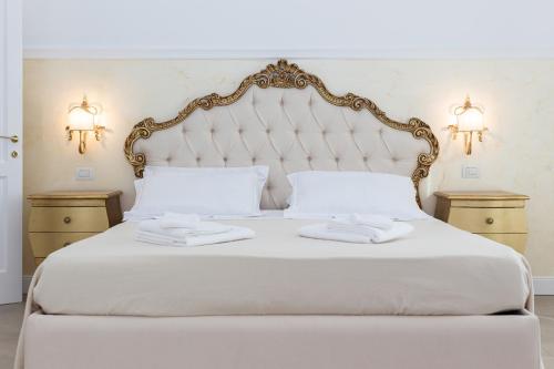 a bedroom with a white bed with two towels on it at Palazzo Marini B&B di Charme in Lecce
