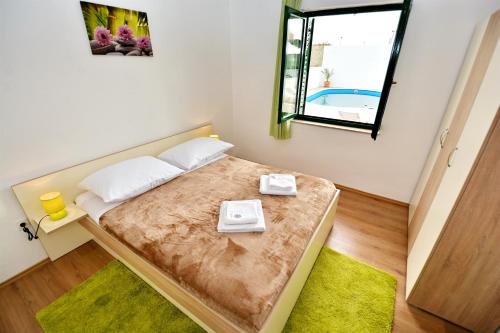 a small bedroom with a bed and a window at Villa Allegro in Sukošan
