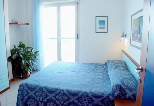 a bedroom with a blue bed and a window at Residence Oltremare in San Benedetto del Tronto