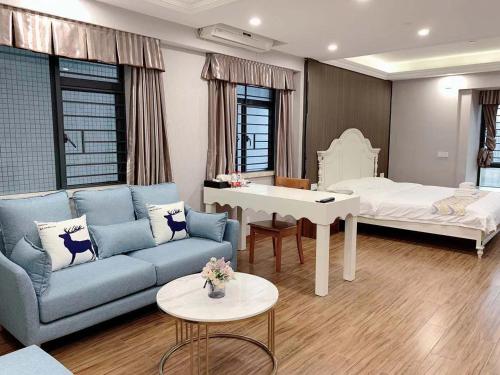 - un salon avec un canapé et un lit dans l'établissement Po Si Zhineng Apartment, à Zhongshan