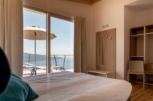 - une chambre avec un lit et une vue sur l'océan dans l'établissement BORGO BEATRICE, à Tignale