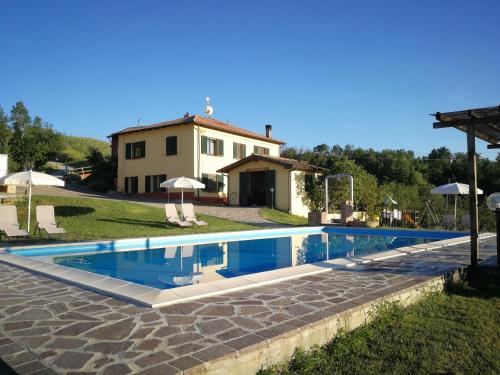a large swimming pool in front of a house at Tenuta MonteOliveto - Romantic Cottage - Agriturismo nelle Langhe in Vesime