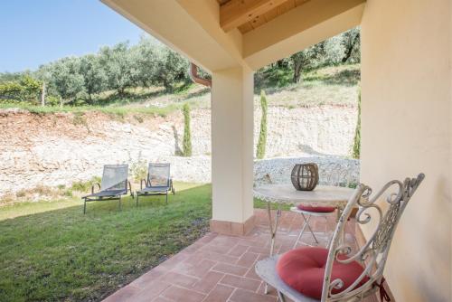 a patio with two chairs and a table on a porch at Maso Maroni Agriturismo in Quinto di Valpantena
