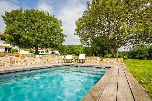 a swimming pool with a table and chairs in a yard at RETREAT KEYWEEK House with Character Pool Fireplace and Garden in Arcangues