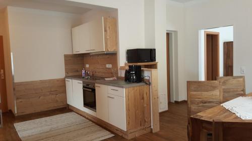 uma pequena cozinha com fogão e micro-ondas em Appartement Juns em Tux