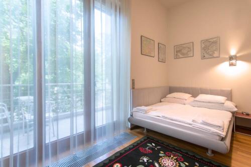 a bedroom with a bed and a large window at Huge luxury central Prague VILLA, 6 beds and baths, terraces, double garage in Prague