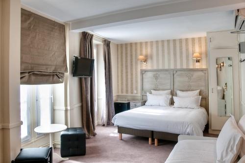 Habitación de hotel con cama y TV en Hôtel de la Motte Picquet, en París