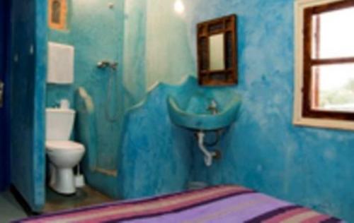 a blue bathroom with a sink and a toilet at Hôtel Chellal Ouzoud in Ouzoud