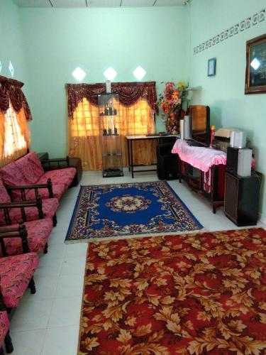 a living room with a couch and a rug at Homestay Damai Sri Kota in Kepala Batas
