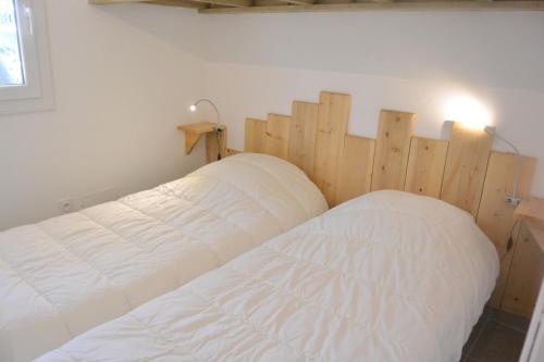 um quarto com uma cama e uma cabeceira em madeira em St CYPRIEN C20 em San Ciprianu