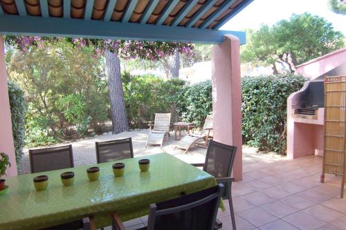 un tavolo verde e sedie su un patio di St CYPRIEN C20 a San Ciprianu
