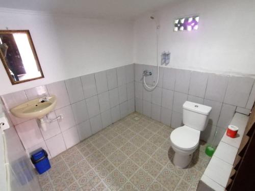 a bathroom with a toilet and a sink at Bale Hostel in Kuta Lombok