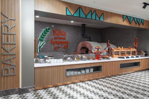 a restaurant with a counter with a pizza oven at Side Royal Style Hotel in Side
