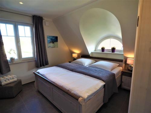 a bedroom with a large bed with an arched window at Freistehende Ferienwohnung in Rerik mit Sauna in Rerik