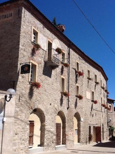 a large stone building with windows and a balcony at Dimora Storico Romantica Il Sole E La Luna in Cerretto Langhe