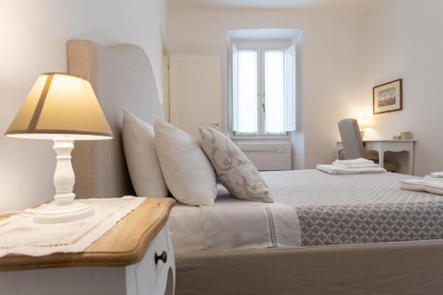 a bedroom with a bed with a lamp and a window at Mercatale Apartment in Prato