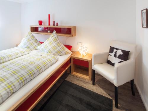 a bedroom with a bed and a chair and a desk at Ferienwohnungen Weidach in Oberstdorf