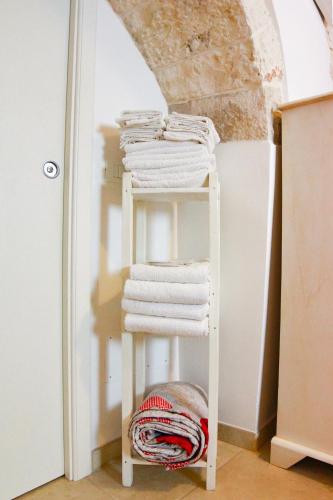 a stack of towels on a shelf in a room at Trulli Borgo Lamie in Locorotondo