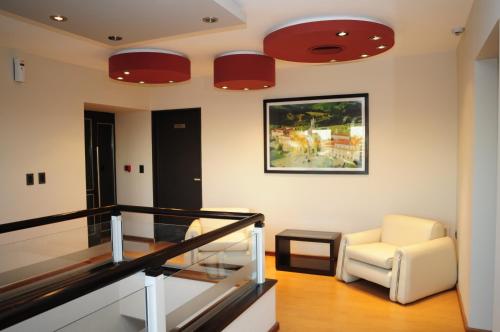 a living room with a white chair and red lights at Hotel Euzko Alkartasuna in Macachín