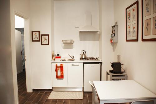 una pequeña cocina blanca con fregadero y mesa en La Casetta di Alvaro, en Domegliara