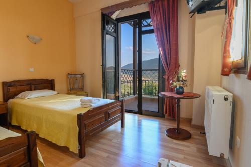 a bedroom with a bed and a balcony with a view at Hotel Siatista in Siatista