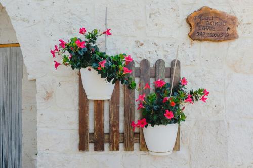a wooden fence with two potted plants on it at Trulli Borgo Lamie in Locorotondo