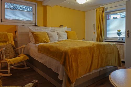 sypialnia z dużym łóżkiem i żółtym kocem w obiekcie HIER & JETZT in Monschau City w mieście Monschau