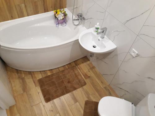 a bathroom with a tub and a sink and a toilet at Apartment on Karla Marksa Avenue in Kryvyi Rih