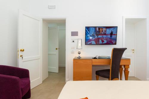 a room with a desk and a table with a chair at Palazzo Marini B&B di Charme in Lecce