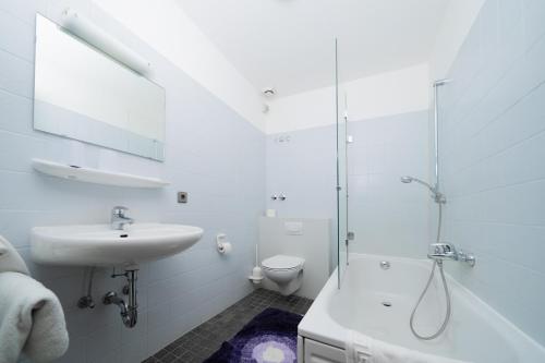 La salle de bains blanche est pourvue d'un lavabo et d'une douche. dans l'établissement Hotel Emshof, à Warendorf