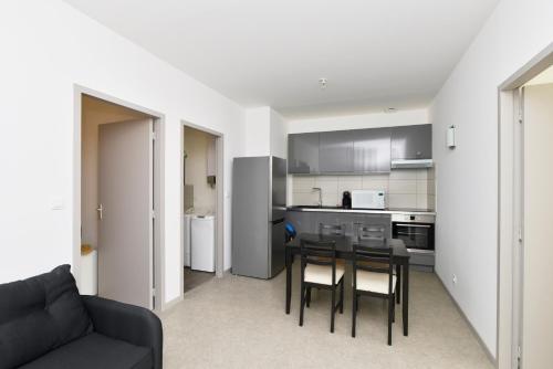 une cuisine et une salle à manger avec une table et des chaises dans l'établissement Heptagone, à Saint-Quentin